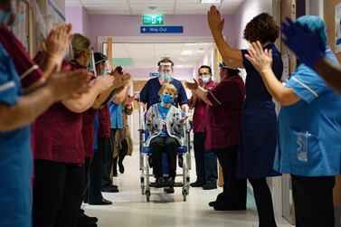 Hospital staff applaud after Margaret Keenan, centre, became the first person in the world to get the Pfizer vaccine. AFP 