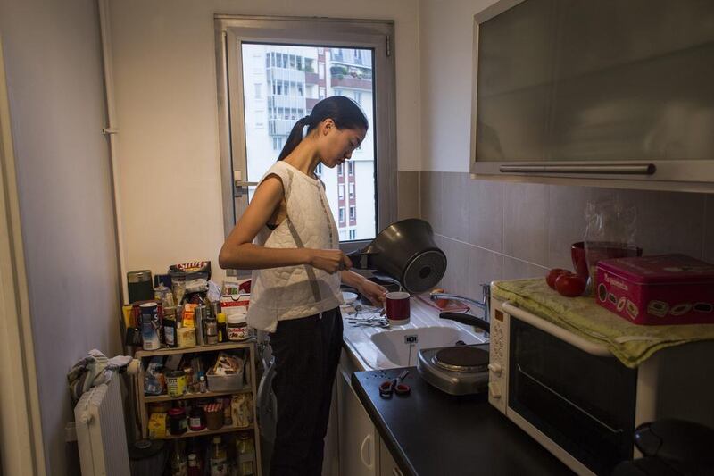 Qiwen Feng prepares a cup of tea in her apartment ahead of a busy day during Paris Fashion Week. Yoan Valat / EPA