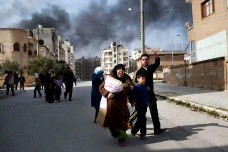 A family escapes from fighting between Free Syrian Army fighters and government troops in Idlib Saturday.