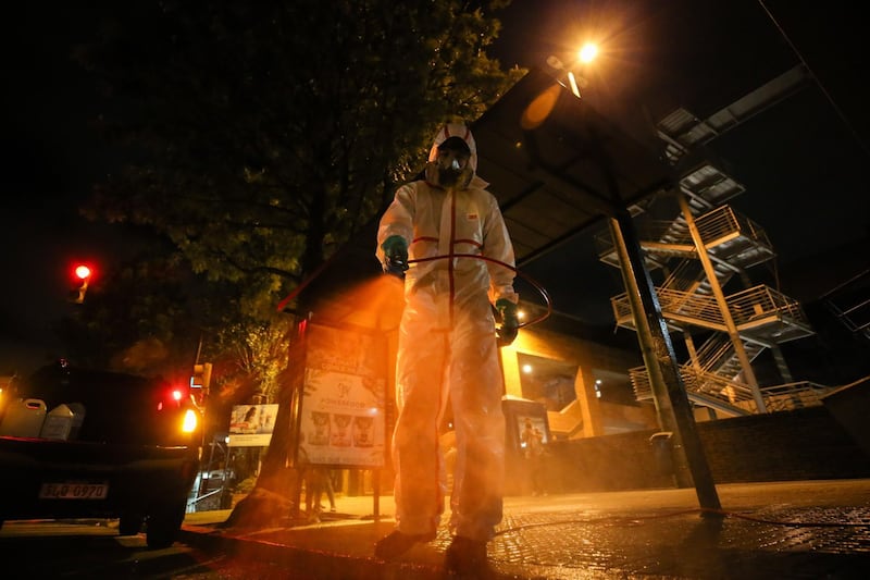 A municipality worker sprays disinfectant at a bus stop as a preventive measure against coronavirus in Montevideo, Uruguay.  EPA