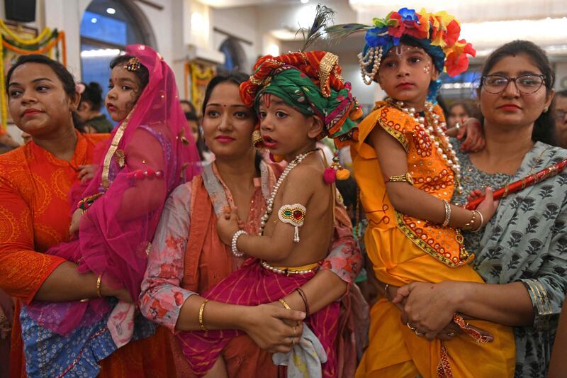 Devotees carry their children dressed as Krishna and Radha. AFP