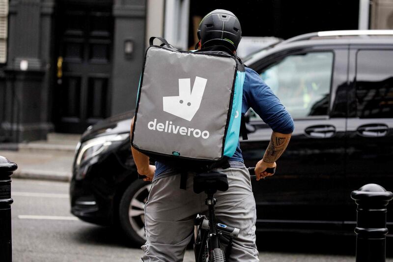 (FILES) In this file photo taken on September 11, 2019 a Deliveroo food courier makes a delivery in central London.. Takeaway meals app Deliveroo on March 4, 2021 said it had chosen London for its stock market listing, a major boost for the capital's financial sector which has been roiled by Brexit.    / AFP / Tolga AKMEN
