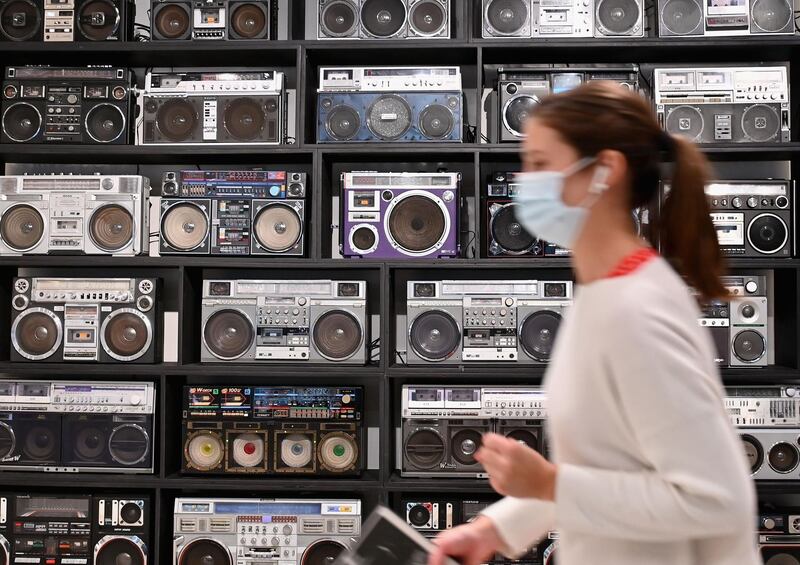 An employee walks past The Wall of Boom by DJ Ross One, an art installation featuring 32 vintage boomboxes as a working sound system displayed during a press preview at Sotheby's for their hip-hop auction. AFP