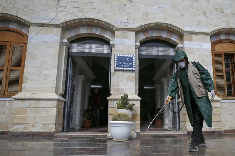 A Palestinian municipal worker sprays disinfectant in the Gaza City Park on March 9, 2020. AFP