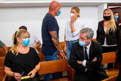 Israeli top model Bar Refaeli (C-R), her mother, Zipi (L), her father, Raffi (C-L) and lawyers are pictured in a court in Tel Aviv, a court in Tel Aviv, on July 20, 2020. Refaeli signed a plea bargain agreement with authorities to settle a long-standing tax evasion case against her and her family. The deal will require Refaeli to serve nine months of community service while her mother, Zipi, will be sent to prison for 16 months. The two are also ordered to pay a $1.5 million fine on top of millions of back taxes owed to the state. / AFP / POOL / Oded Balilty
