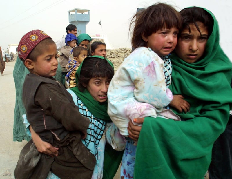 395692 05: Afghans refugees walk across the border into Pakistan October 11, 2001 as they leave Afghanistan at the Chaman crossing point on the 4th day of U.S.-led air strikes against the ruling Taliban and terrorist networks in the country. The Chaman border is the closest entrance to Pakistan from Kandahar. (Photo by Paula Bronstein/Getty Images)