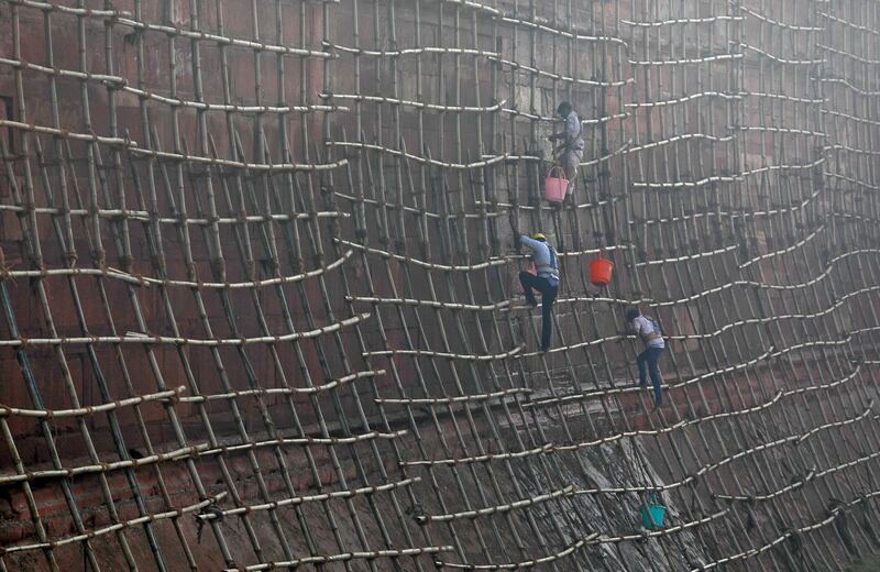 Workers climb scaffolding to clean the walls of the historic Red Fort in the old quarters of Delhi, India. Saumya Khandelwal / Reuters.