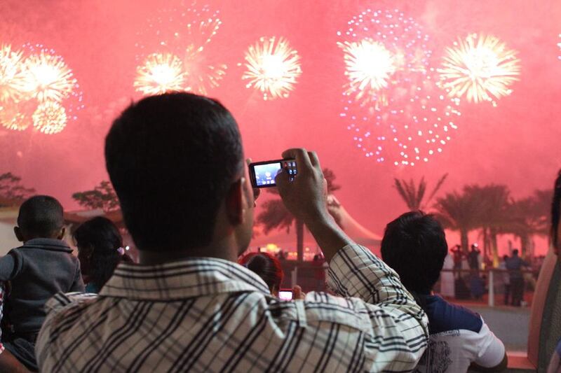 People watch the National Day fireworks along the Corniche in Abu Dhabi. Silvia Razgova / The National