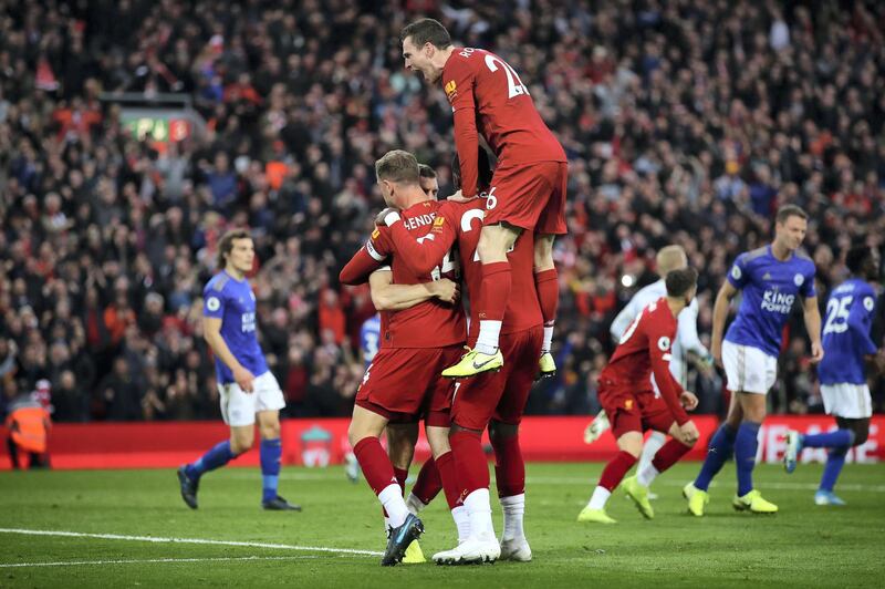 LIVERPOOL, ENGLAND - OCTOBER 05: James Milner of Liverpool celebrates with Jordan Henderson of Liverpool and Divock Origi of Liverpool and Andy Robertson of Liverpool  after he scores his sides second goal from the penalty spot during the Premier League match between Liverpool FC and Leicester City at Anfield on October 05, 2019 in Liverpool, United Kingdom. (Photo by Clive Brunskill/Getty Images)