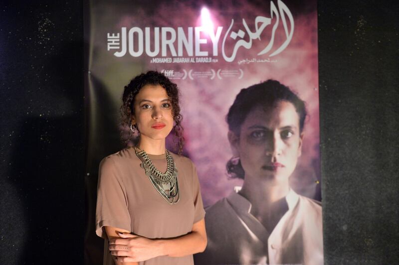 Iraqi-Lebanese actress and cast member Zahraa Ghandour poses in front of a poster of her film 'The Journey' (Al Rahal) in Beirut, Lebanon.  EPA