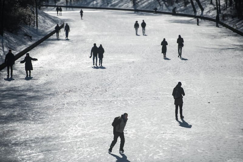 People skate and walk on a frozen Landwehr Canal after a recent snowstorm dumped snow across central Germany. Getty