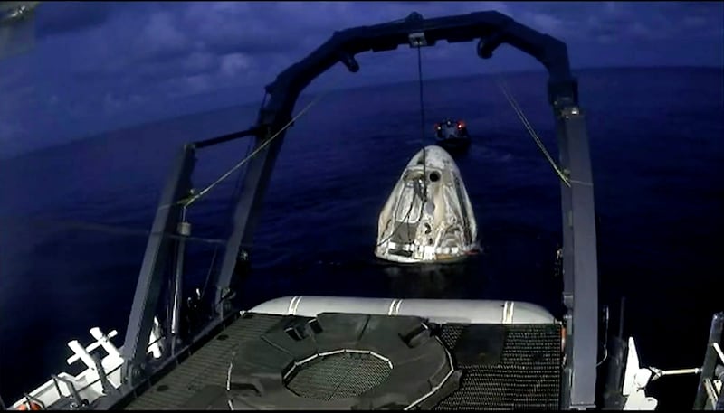 A SpaceX capsule carrying four people is lifted from the Atlantic Ocean on to a recovery vessel. AP