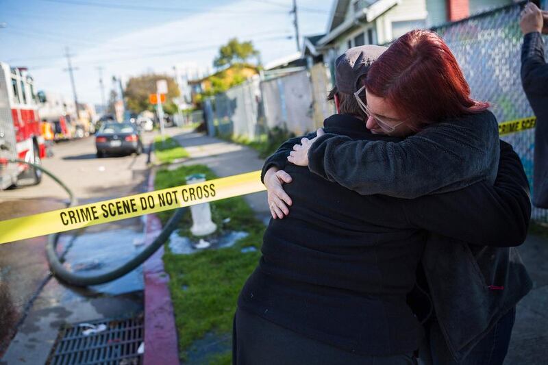 Mourners gather near a warehouse after it was destroyed by a fire in Oakland, California. Up to 40 people were feared dead the blaze. Nick Otto / AFP Photo