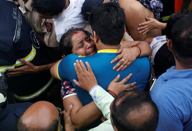 A woman hugs her family member after she was rescued during a fire at a residential building in Mumbai, India. Reuters
