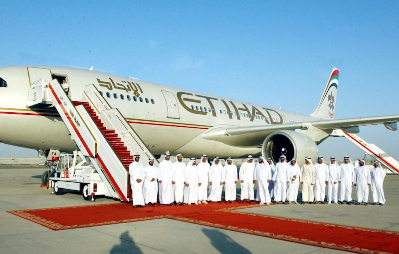 Emirati officials pose in front of the new carrier "Etihad" or "Unity" which was on show in the capital Abu Dhabi 03 November 2003. A day after the inaugural flight of Air Arabia, a no frills airline launched in the United Arab Emirates, the capital Abu Dhabi announced it would be setting up Etihad as a new carrier. Etihad, which is yet to be formally launched, is backed by the government of Abu Dhabi and has a paid up capital of 500 million dirhams (136 million dollars), reported today's Gulf News. Etihad, meaning unity, which has two leased Airbus A330-200 aircraft, will make its inaugural flight on November 5, flying from Abu Dhabi to the UAE desert city of Al Ain. AFP PHOTO/WAM (Photo by WAM / AFP)