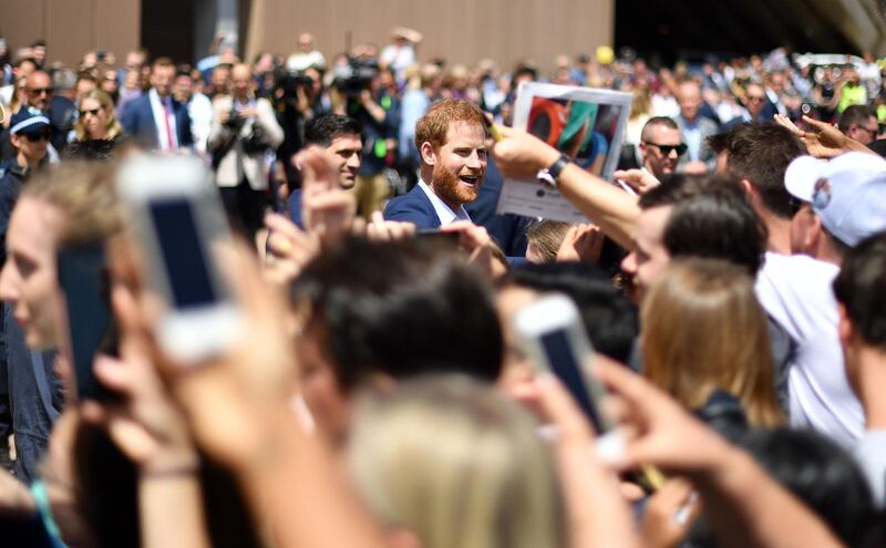 Prince Harry smiles as he meets people outside the Sydney Opera House. AFP