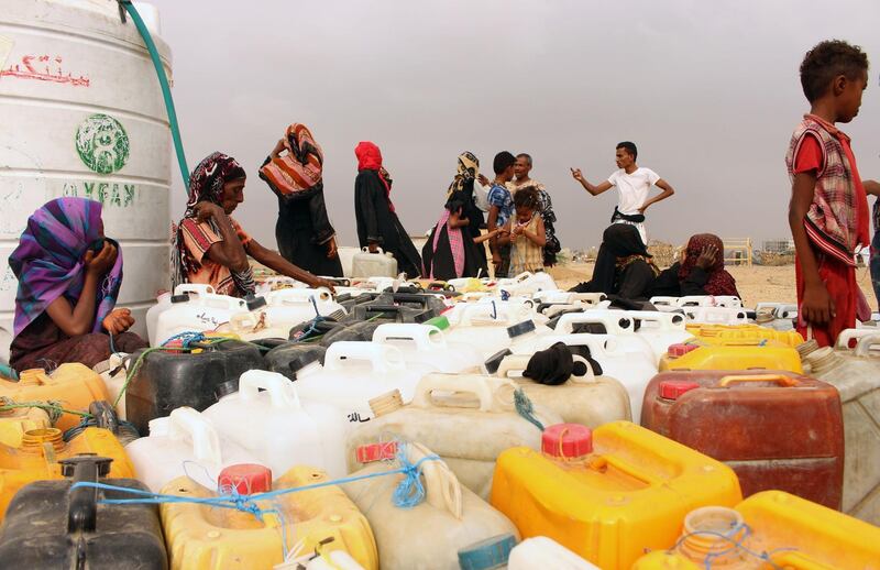 Yemenis fill jerrycans with water at a makeshift camp in the district of Abs, in Yemen's northwestern Hajjah province. AFP