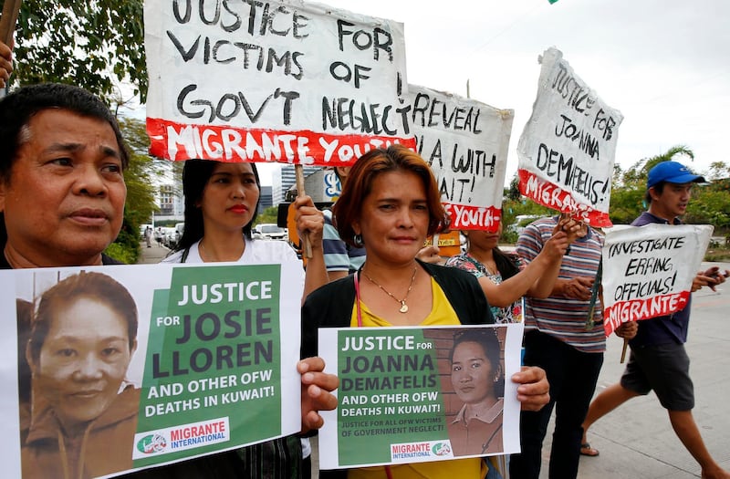 FILE - In this Wednesday, Feb. 21, 2018, file photo, protesters picket the Senate at the start of the probe in the death of an overseas worker in Kuwait, Pasay city south of Manila, Philippines. The senate probe was prompted by the discovery of the corpse of Filipino domestic help Joanna Demafelis stuffed in a freezer in Kuwait with President Rodrigo Duterte ordering repatriations of thousands of Filipino workers and banned future deployments to the oil-rich nation. (AP Photo/Bullit Marquez, File)