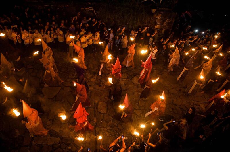 Hooded catholic faithful representing Roman soldiers, known as "Farricocos", carry flaming torches during the annual Fogareu Holy Week procession in Goias, 350 km west of Brasilia, Brazil. AFP