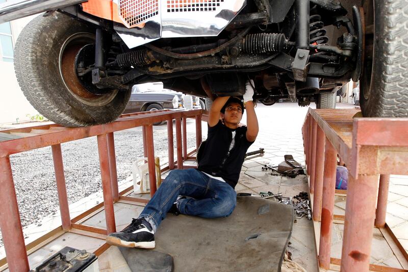 Sharjah, May 9, 2013 - Khalid Mubarak, 14, gets his hands dirty while fixing a car at his family's classic car "garage" in Sharjah, May 9, 2013.(Photo by: Sarah Dea/The National)

