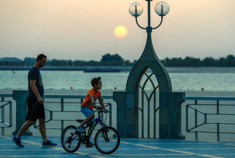 Abu Dhabi, United Arab Emirates, March 27, 2020.   
  Residents enjoy the sunset at the Corniche before the 6 p.m. curfew by the UAE government  on the first day of the  nationwide cleaning campaign to help deter the Coronavirus from spreading.
Victor Besa / The National
Section:  NA
Reporter:  Haneen Dajani
