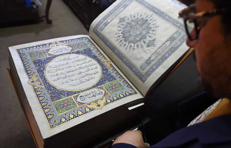 In this photograph taken on April 19, 2018 Afghan master miniature artist Mohammad Tamim Sahibzada shows a handmade Koran made with silk fabric at the Turquoise Mountain Foundation in Mourad Khani, in the old city section of Kabul. One of the only Korans ever made from silk fabric has been completed in Afghanistan -- a feat its creators hope will help preserve the country's centuries-old tradition of calligraphy. - TO GO WITH: Afghanistan-culture-Koran-calligraphy, FOCUS by Allison JACKSON
 / AFP / WAKIL KOHSAR / TO GO WITH: Afghanistan-culture-Koran-calligraphy, FOCUS by Allison JACKSON
