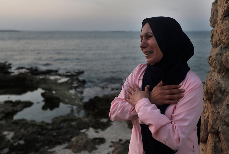 Lebanese woman Afaf Adulhamid, the mother of Mohammed Khaldoun, 27, who is still missing at sea while he was trying with other migrants to reach Cyprus on a boat, cries and prays her son's safe return, as she stands on the coast of Tripoli city, north Lebanon. AP Photo