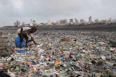 A man collects rubbish from the shores of the Arabian Sea in India. Rafiq Maqbool / AP