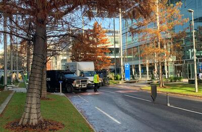 Police armoured vehicles parked at the entrance to Chiswick Business Park. The National