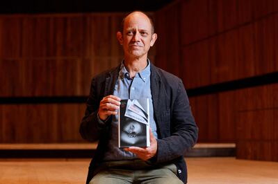 South African author Damon Galgut poses with his book 'The Promise' during a photocall for the 2021 Booker Prize for Fiction-shortlisted authors, at London's Southbank Centre, in October 2021. AFP