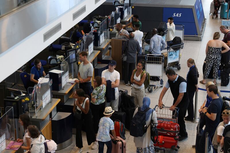 Travellers queue at bag drop for Scandinavian Airlines at Copenhagen Airport in Denmark. Reuters
