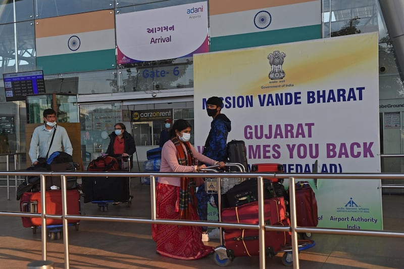 Passengers are seen upon their arrival from the United Kingdom after they went through a Covid-19 coronavirus test at the Sardar Vallabhbhai Patel International Airport in Ahmedabad on December 22, 2020. (Photo by Sam PANTHAKY / AFP)