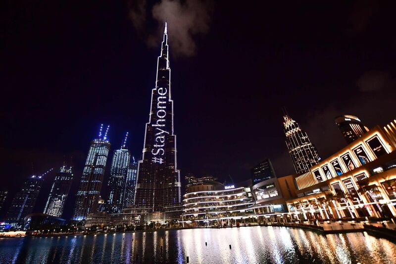 A picture shows Dubai's Burj Khalifa lit up with a message "Stay Home" reminding citizens to stay home amid the coronavirus COVID-19 pandemic, on March 24, 2020. / AFP / Giuseppe CACACE

