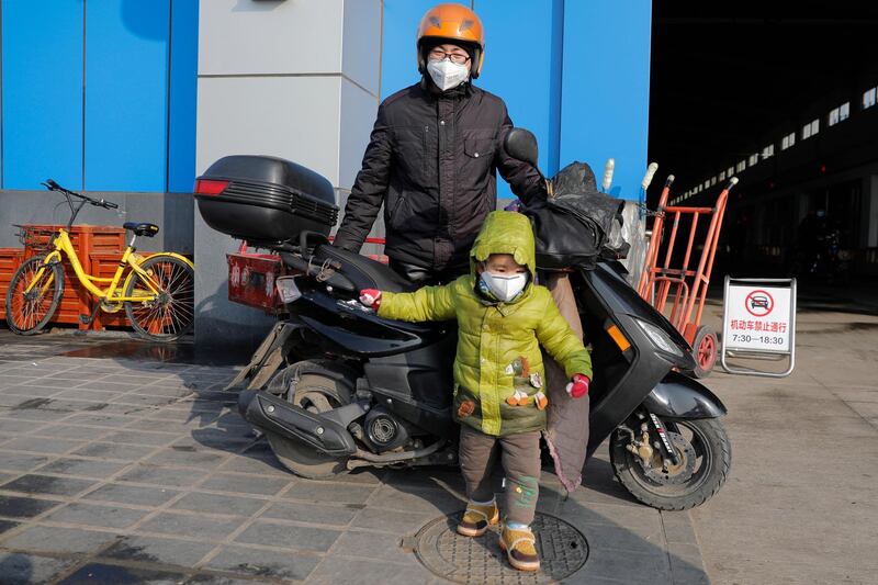 A man and his child wear protective masks at a market in Beijing, China.  EPA