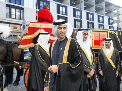 His Excellency Mansoor Abdulhoul following his visit with Her Majesty The Queen at Buckingham Pallace for the presentation of diplomatic credentials. Seen here with his wife in red with black hat, Victoria Devin and the deputy Marshal of the Diplomatic Core with feathers in hat. Outside the Lanesborough Hotel in central London where the reception HE Mansoor Abdulhoul's in D'honneur took place.