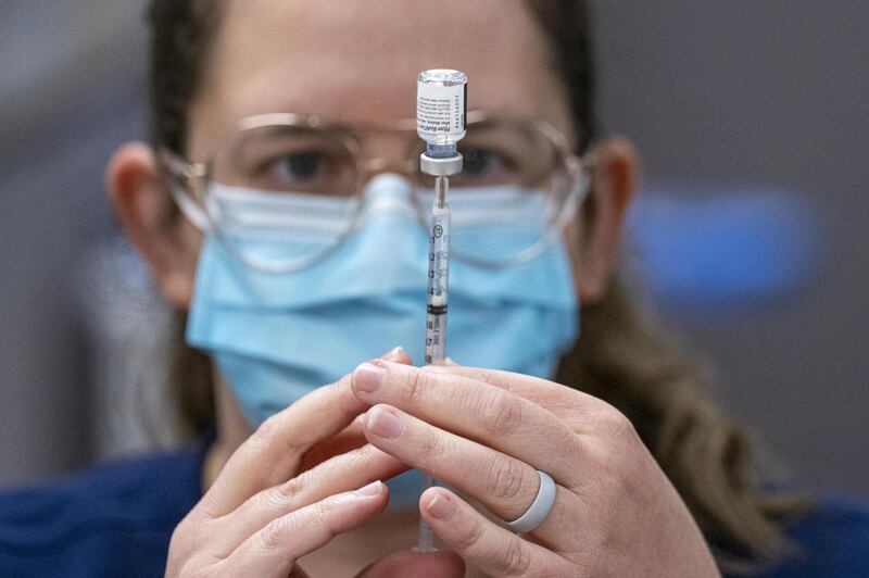 A healthcare worker fills a syringe with a dose of the Pfizer-BioNTech Covid-19 vaccine at a large-scale vaccination site in Sacramento, California, USA. Bloomberg