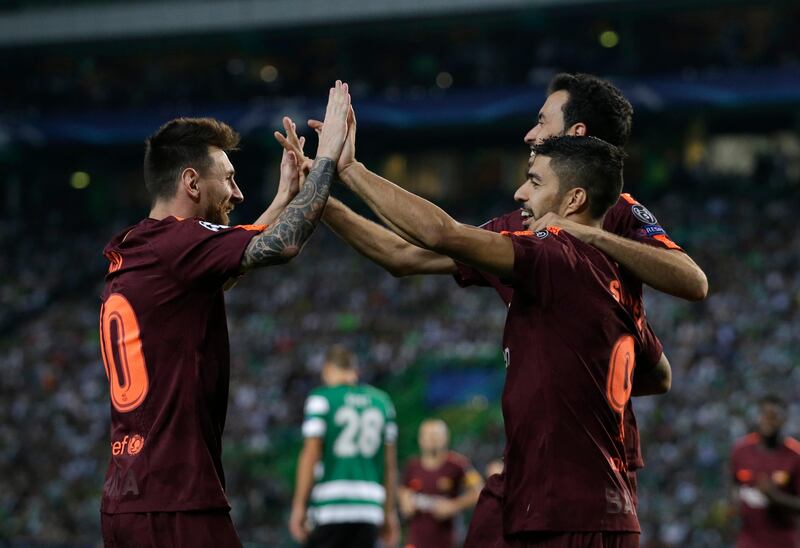 Barcelona's Lionel Messi and Luis Suarez celebrate after an own goal by Sporting's Sebastian Coates. Armando Franca / AP Photo