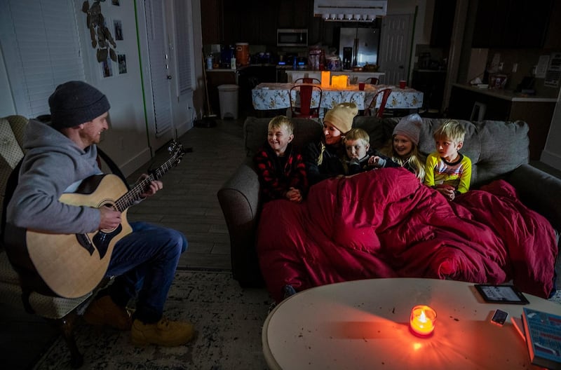 Brett Archibad entertains his family as they try to stay warm in their home the Blackhawk district in Pflugerville, Texas. Anger about the state’s power grid failure mounted on Tuesday. AP