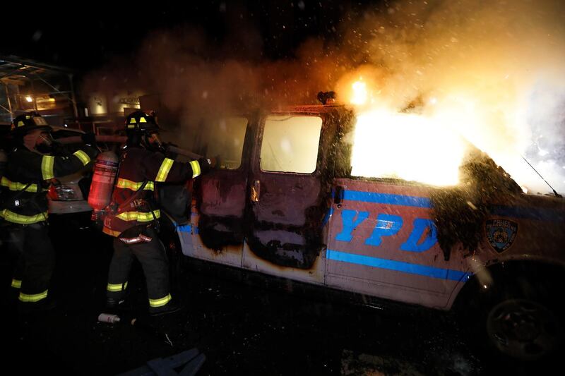 New York City firefighters spray water on a police van set ablaze during protests at Union Square, New York, US.  EPA