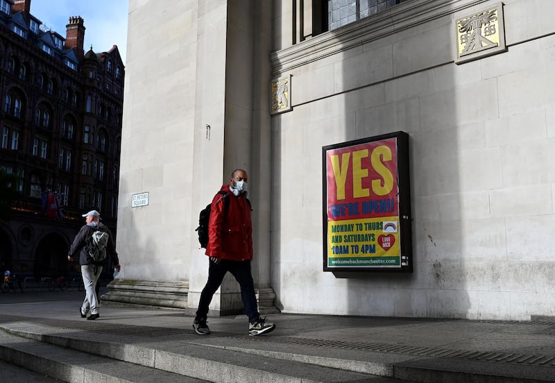 A pedestrian walks past Manchester Central Library following the midday deadline to agree to voluntarily move into the British Government's 'Tier 3'. AFP