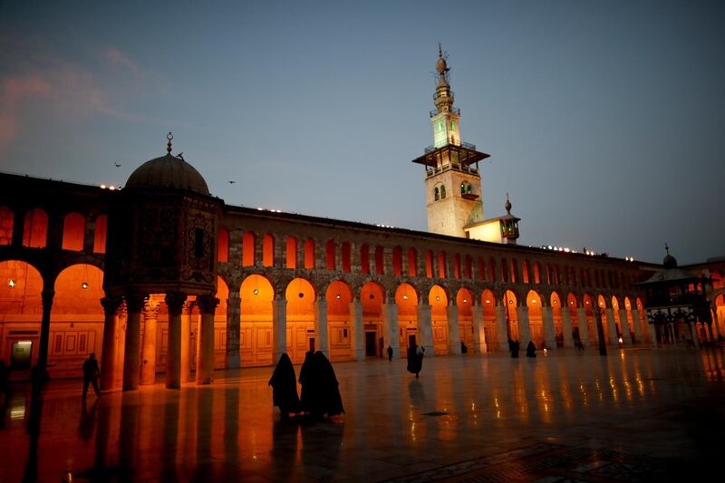 Muslim women walk in the courtyard of the 7th century Umayyad Mosque in Damascus, Syria, Wednesday, Oct. 3, 2018. President Bashar Assad told a little-known Kuwaiti newspaper Wednesday that Syria has reached a "major understanding" with Arab states after years of hostility over the country's civil war. (AP Photo/Hassan Ammar)