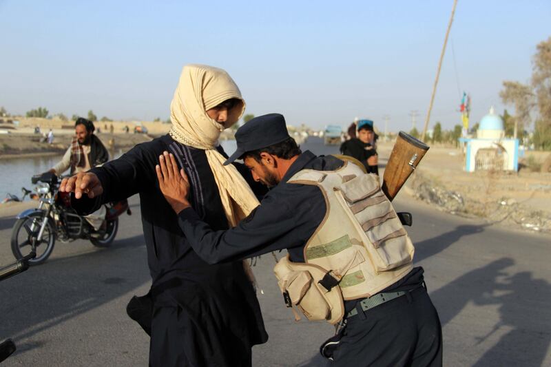 epa06104154 Afghan Police search people on a highway leading to Shah Wali Khan district, in Kandahar, Afghanistan, 22 July 2017. According to reports around 70 Afghan villagers were kidnapped on 21 July, allegedly by Taliban militants from a highway near Shah Wali Khan district, of which seven were reportedly killed.  EPA/MUHAMMAD SADIQ