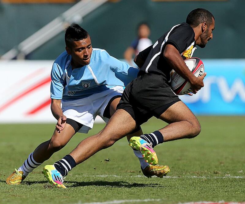 Al Ain Mixed Schools, in black, shown playing Al Maarif Schools, in blue, in the UAE National Schools Final on Saturday at Dubai Sevens. Al Maarif Schools won. Satish Kumar / The National