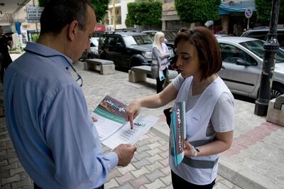 In this picture taken on Saturday, April 28, 2018, Lebanese elections candidate Laury Haytayan, 42, right, speaks to voter in Beirut's Ashrafieh district, Lebanon. Haytayan is running for Parliament on the Kulna Watani list, a coalition of civic activists, businessmen, journalists, and engineers challenging the country's traditional parties for power, in Lebanon's first national elections in 9 years. (AP Photo/Philip Issa)