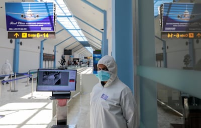 A security officer wearing protective gear stands next to passenger temperature scanning machine where she is on duty as Sri Lanka's government scheduled to reopen the country's airports for tourists from January 21, 2021, as they were closed since March 2020 due to spread of  coronavirus disease (COVID-19), at Bandaranaike International Airport in Katunayake, Sri Lanka January 20, 2021. REUTERS/Dinuka Liyanawatte