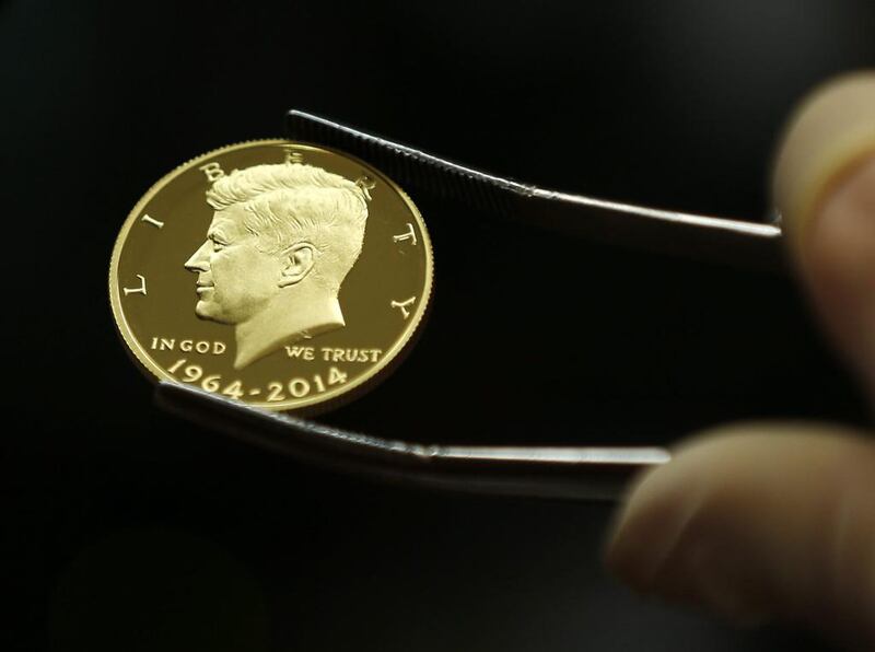 A newly-stamped gold coin of President John F Kennedy is examined at the US Mint at West Point. AP Photo