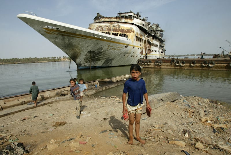 (FILES) This file photo taken on May 13, 2003 shows Iraqi children in front of Iraqi dictator Saddam Hussein's luxury yacht the al-Mansur moored in Basra after it was bombed during the US-led invasion of Iraq that ended Saddam's decades of iron-fisted rule.  - Measuring 120 metres in length and weighing over 7,000 tonnes, the former presidential yacht had been assembled in Finland and delivered to Iraq in 1983, according to the website of Danish designer Knud E.  Hansen.  (Photo by PHILIPPE DESMAZES  /  AFP)