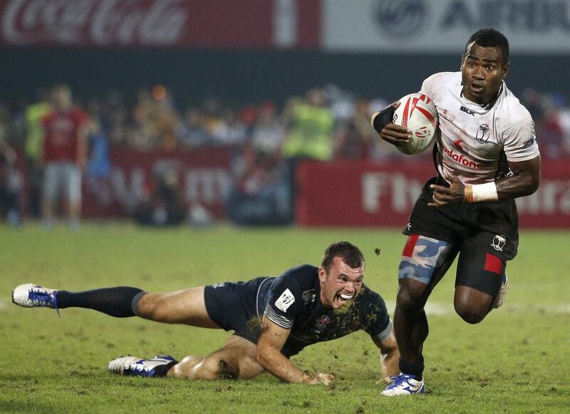 Fiji's Jerry Tuwai avoids the tackle of England's Tom Bowen during their rugby final match in Dubai. World champions Fiji won the Dubai Sevens with a 28-17 victory. AFP 