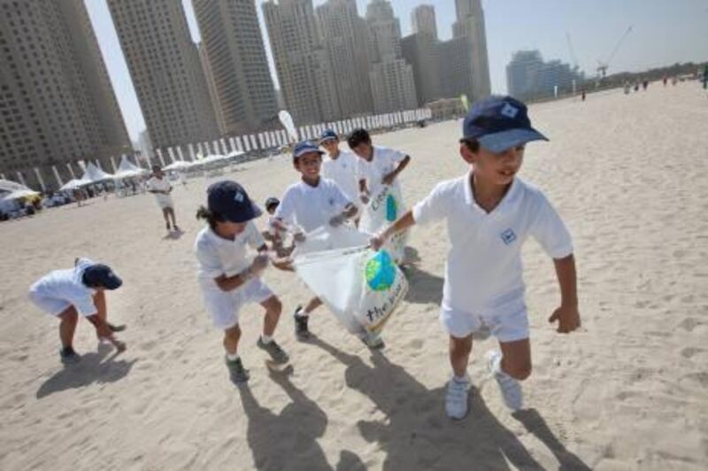 UAE - Dubai - Oct 26- 2010:  Kids volunteers during the first day of the Clean Up Campaign run by Dubai Municipality at the beach in front of Jumeirah Beach Residence. ( Jaime Puebla - The National Newspaper )