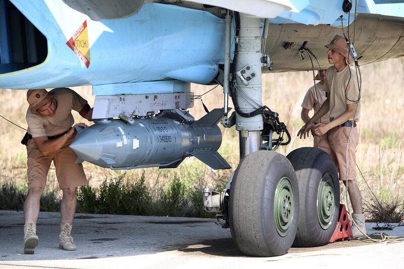 Russian military support crew attach a satellite guided bomb in Syria. Alexander Kots / AP
